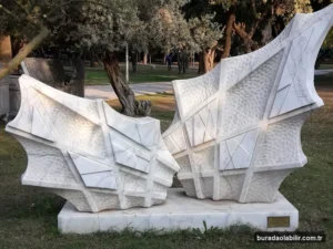 Buca Hasanağa Bahçesi yeşil park dokusu ağaçlıklı yürüyüş yolları ve dinlenme alanları