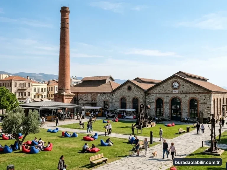Havagazı Fabrikası Alsancak kırmızı tuğla bacası, endüstriyel taş binaları ve yeşil çim avlusu