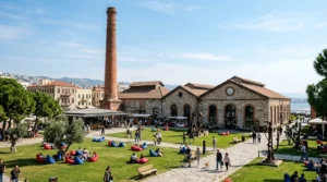 Tarihi Havagazı Fabrikası Alsancak kırmızı tuğla bacası, endüstriyel taş binaları ve yeşil çim avlusu